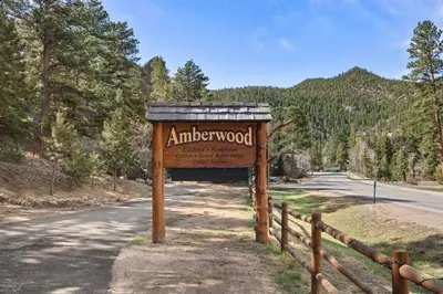 a sign for an antlerwood sign on the side of a road at Cabin 20- King Cabin w Roku TV Full Kitchen in Estes Park