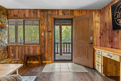 a room with wooden walls and a wooden door at Cabin 20- King Cabin w Roku TV Full Kitchen in Estes Park