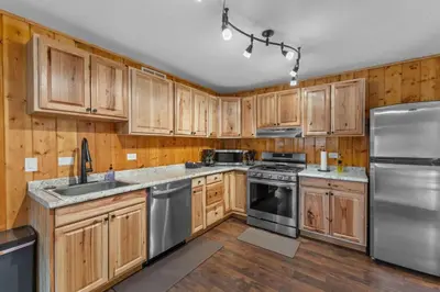 a kitchen with wooden cabinets and stainless steel appliances at Cabin 21- Accessible Unit & King Bed in Estes Park