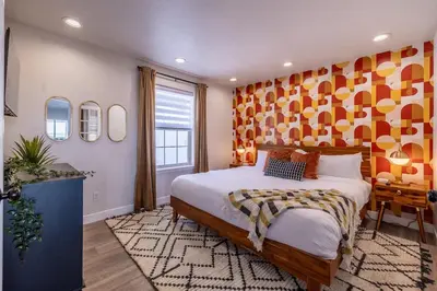 a bedroom with a large bed with a orange wall at Hot Tub w Mountain View in Westminster