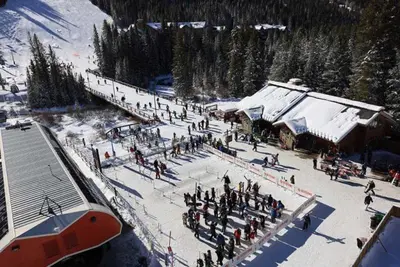 a group of people standing in the snow near a ski lodge at Kindred Resort Luxury Ski In, Ski Out 3 Bedroom Residence At The River Run Gondola in Dillon