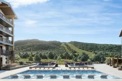 a large swimming pool with a view of a mountain at Kindred Resort Luxury Ski In, Ski Out 3 Bedroom Residence At The River Run Gondola in Dillon