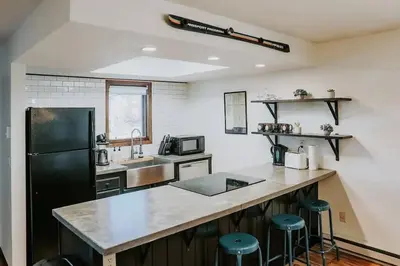 a kitchen with a black refrigerator and a counter at Mountain Escape in Fraser near Winter Park Trails in Fraser