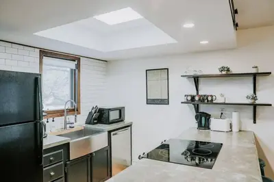 a kitchen with a black refrigerator and a sink at Mountain Escape in Fraser near Winter Park Trails in Fraser