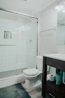 a white bathroom with a toilet and a shower at Mountain Escape in Fraser near Winter Park Trails in Fraser