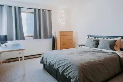 a bedroom with a bed and a desk and a window at Mountain Escape in Fraser near Winter Park Trails in Fraser