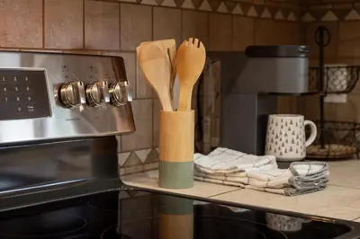 two wooden spoons on a shelf next to a stove at Winter Park Condo with Fireplace, Centrally Located in Winter Park