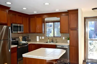 a kitchen with wooden cabinets and a counter top at Winter Park Condo with Fireplace, Centrally Located in Winter Park