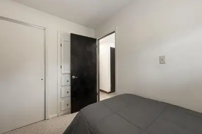 a bedroom with a bed and a black door at Winter Park Condo with Fireplace, Centrally Located in Winter Park