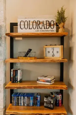 a wooden shelf with a clock and dvds at Ski Granby Ranch five minutes from the house in Granby