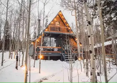 a log cabin in the woods in the snow at Rocky Mountain A Frame in Grand Lake