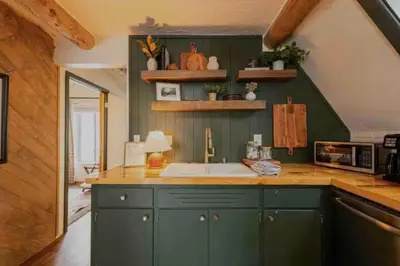 a kitchen with green cabinets and a sink at Rocky Mountain A Frame in Grand Lake