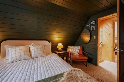 a bedroom with a bed and a chair and a table at Rocky Mountain A Frame in Grand Lake