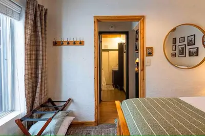a bedroom with a bed and a mirror and a window at Rocky Mountain A Frame in Grand Lake