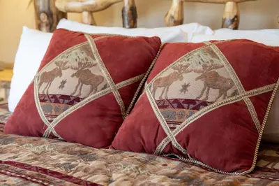 a group of red pillows on a bed at Luxury Lake Condo Walk to Downtown in Grand Lake