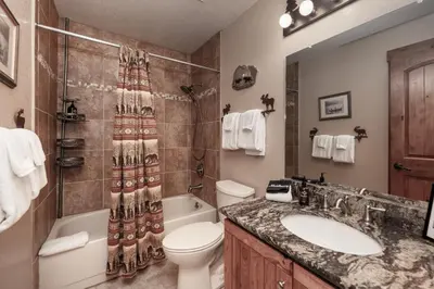 a bathroom with a sink and a toilet and a shower at Luxury Lake Condo Walk to Downtown in Grand Lake