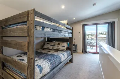 a bedroom with a bunk bed and a balcony at Eagle Nest on Grand Ave in Grand Lake