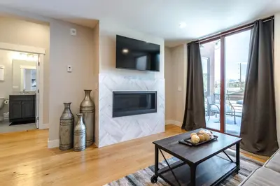 a living room with a fireplace and a tv at Eagle Nest on Grand Ave in Grand Lake