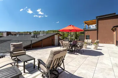 a patio with a table and chairs and an umbrella at Eagle Nest on Grand Ave in Grand Lake