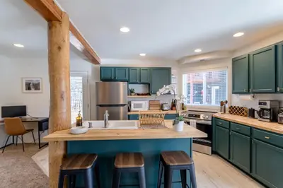 a kitchen with green cabinets and a large island at Cute modern 2 bed retreat, a perfect basecamp in Fraser