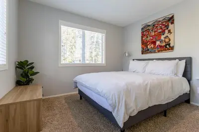 a bedroom with a bed and a painting on the wall at Cute modern 2 bed retreat, a perfect basecamp in Fraser