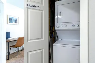 a kitchen with a refrigerator and a washer and dryer at Cute modern 2 bed retreat, a perfect basecamp in Fraser