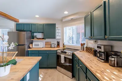 a kitchen with green cabinets and a counter top at Cute modern 2 bed retreat, a perfect basecamp in Fraser
