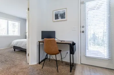 a desk with a computer and a chair in a bedroom at Cute modern 2 bed retreat, a perfect basecamp in Fraser