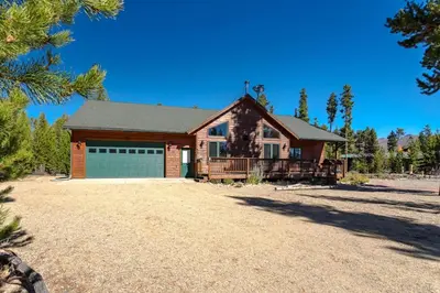 a house with a garage on a gravel driveway at Spacious Pet-Friendly Grand Lake House in Grand Lake
