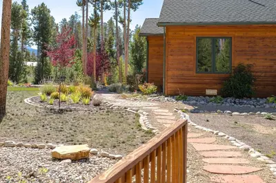 a garden with a wooden house and a stone walkway at Spacious Pet-Friendly Grand Lake House in Grand Lake