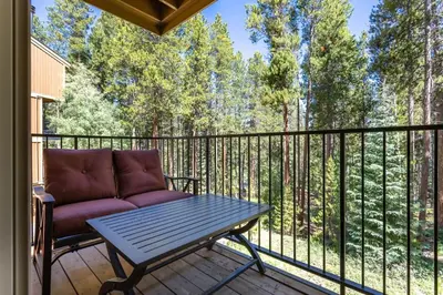 a patio with a couch and a table on a balcony at Winter Park Mountain Retreat with Stunning Views in Winter Park