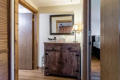 a room with a dresser with a mirror and a bed at Winter Park Mountain Retreat with Stunning Views in Winter Park