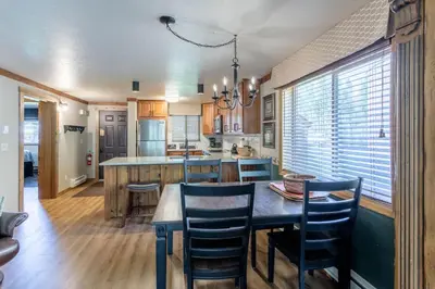 a kitchen with a wooden table and chairs and a dining room at Winter Park Mountain Retreat with Stunning Views in Winter Park