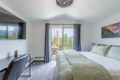 a bedroom with a bed and a desk and a window at 3 BR Fraser Apartment in Fraser