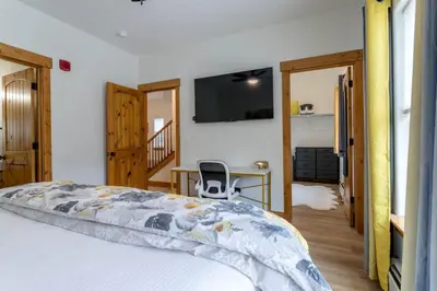 a bedroom with a bed and a desk and a tv at 3 BR Fraser Apartment in Fraser
