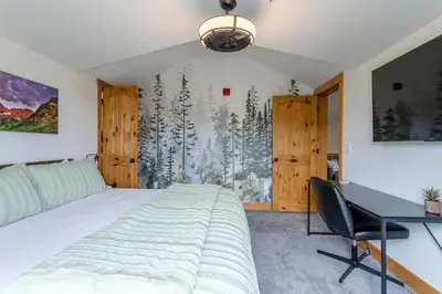 a bedroom with a bed and a desk and a window at 3 BR Fraser Apartment in Fraser