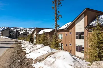 a snowy road in front of a building at Winter Park 3BR Townhouse with Mountain views in Fraser