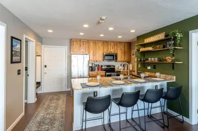 a kitchen with a large island with bar stools at Ski in ski out condo in Granby in Granby