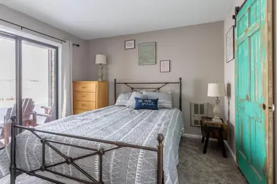 a bedroom with a bed and a large window at Ski in ski out condo in Granby in Granby