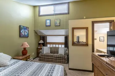 a bedroom with a bed and a couch and a television at Fraser 3BR Condo with Pool and Hot Tub in Fraser