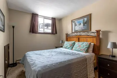 a bedroom with a bed with a wooden head board at Fraser 3BR Condo with Pool and Hot Tub in Fraser