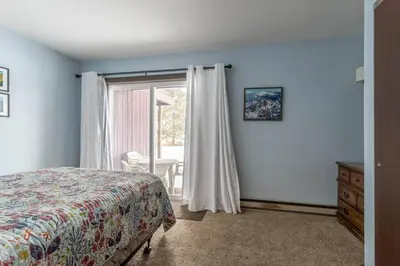 a bedroom with a bed and a sliding glass door at Fraser 3BR Condo with Pool and Hot Tub in Fraser