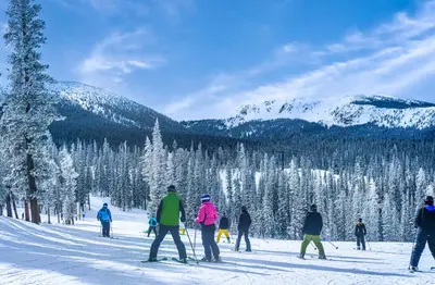a group of people skiing down a snow covered slope at Fraser 3BR Condo with Pool and Hot Tub in Fraser
