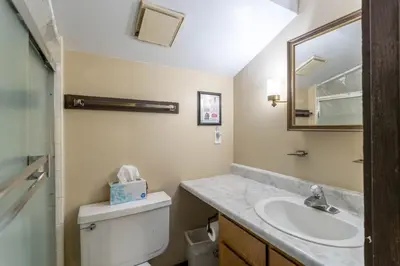 a bathroom with a sink and a toilet and a mirror at Fraser 3BR Condo with Pool and Hot Tub in Fraser