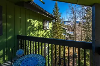 a balcony with a table and chairs on a green house at WP Top Floor Getaway in Winter Park