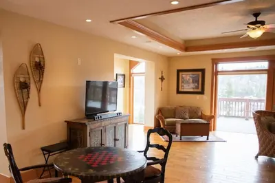 a living room with a table and a tv at Scenic Mountain Retreat in Fraser in Granby