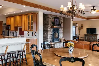 a kitchen and living room with a table and a fireplace at Scenic Mountain Retreat in Fraser in Granby