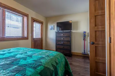 a bedroom with a bed and a dresser and a television at Love Grand Lake Townhouse Pet Friendly With garage in Grand Lake