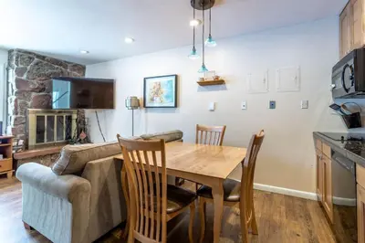 a kitchen and dining room with a table and a couch at Winter Park Condo with Fireplace and Mountain Views in Winter Park