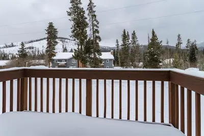 a snow covered balcony with a view of a mountain at Winter Park Condo with Fireplace and Mountain Views in Winter Park